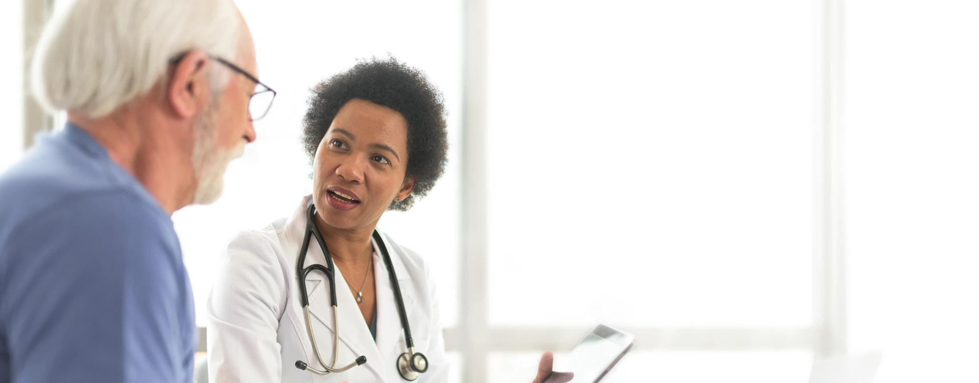 A physician talking with an older male patient